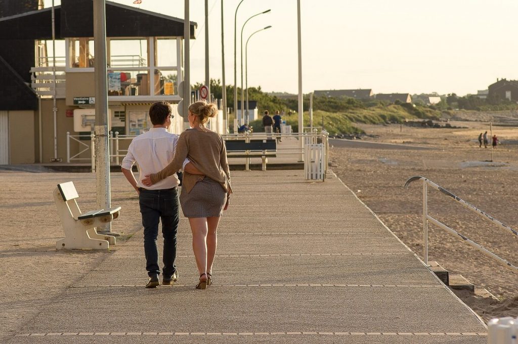 couple qui se balade sur la digue de bernieres sur mer