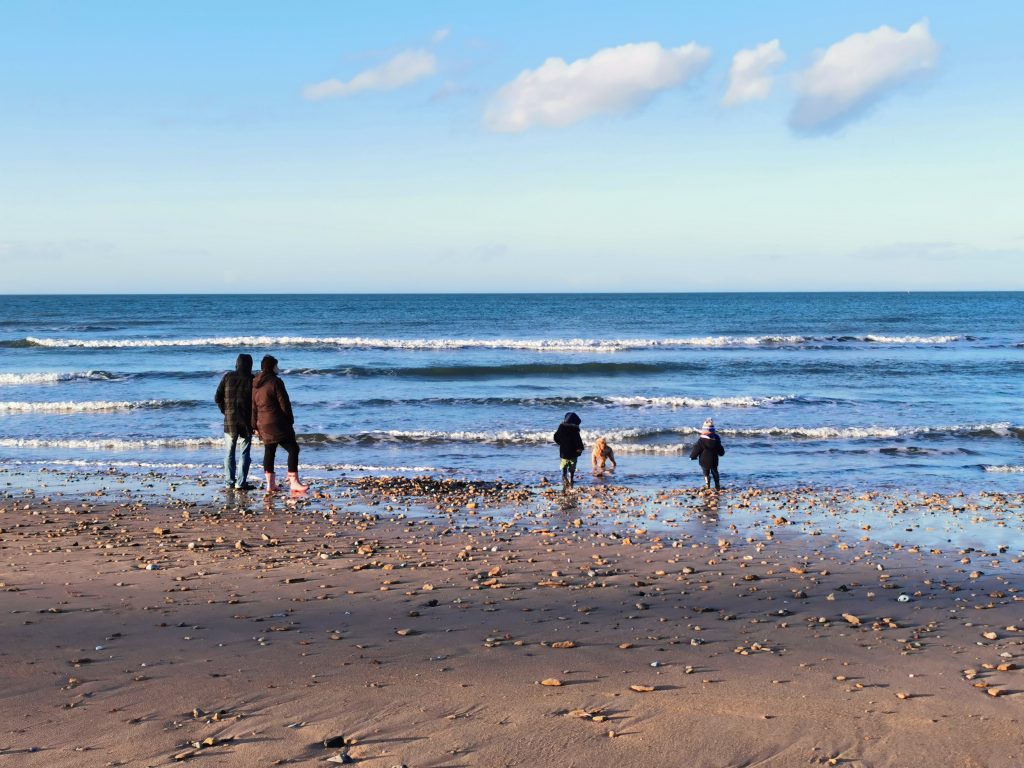 famille avec enfants au bord de la mer en hiver