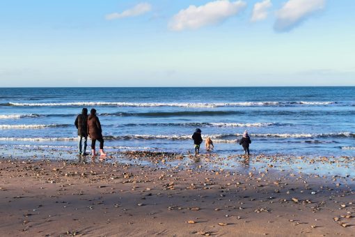 family with children by the sea in winter