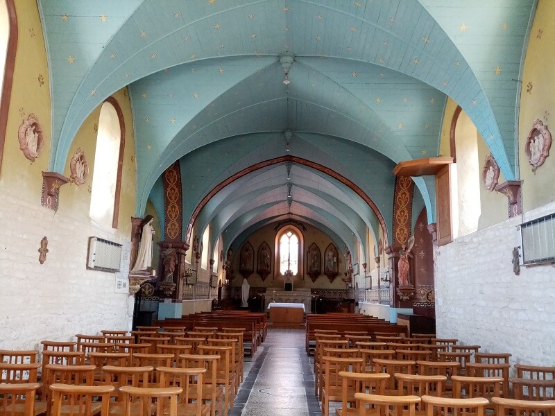 Het interieur van de kerk, met de muren geel geschilderd en de gewelven in hemelsblauw.