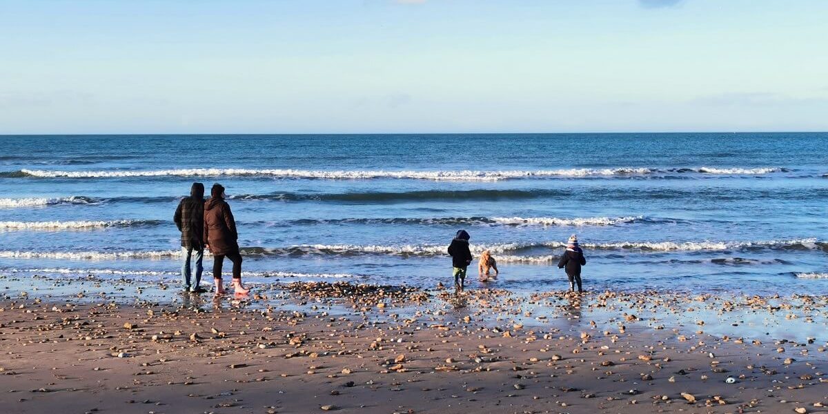 family with children on the beach in winter