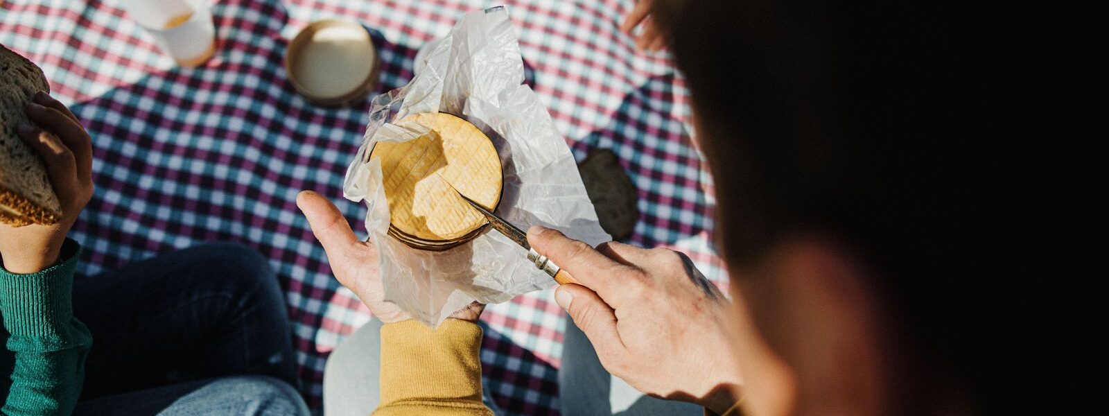 Instant gourmand : dégustation de produits locaux sur une nappe à carreaux traditionnelle.